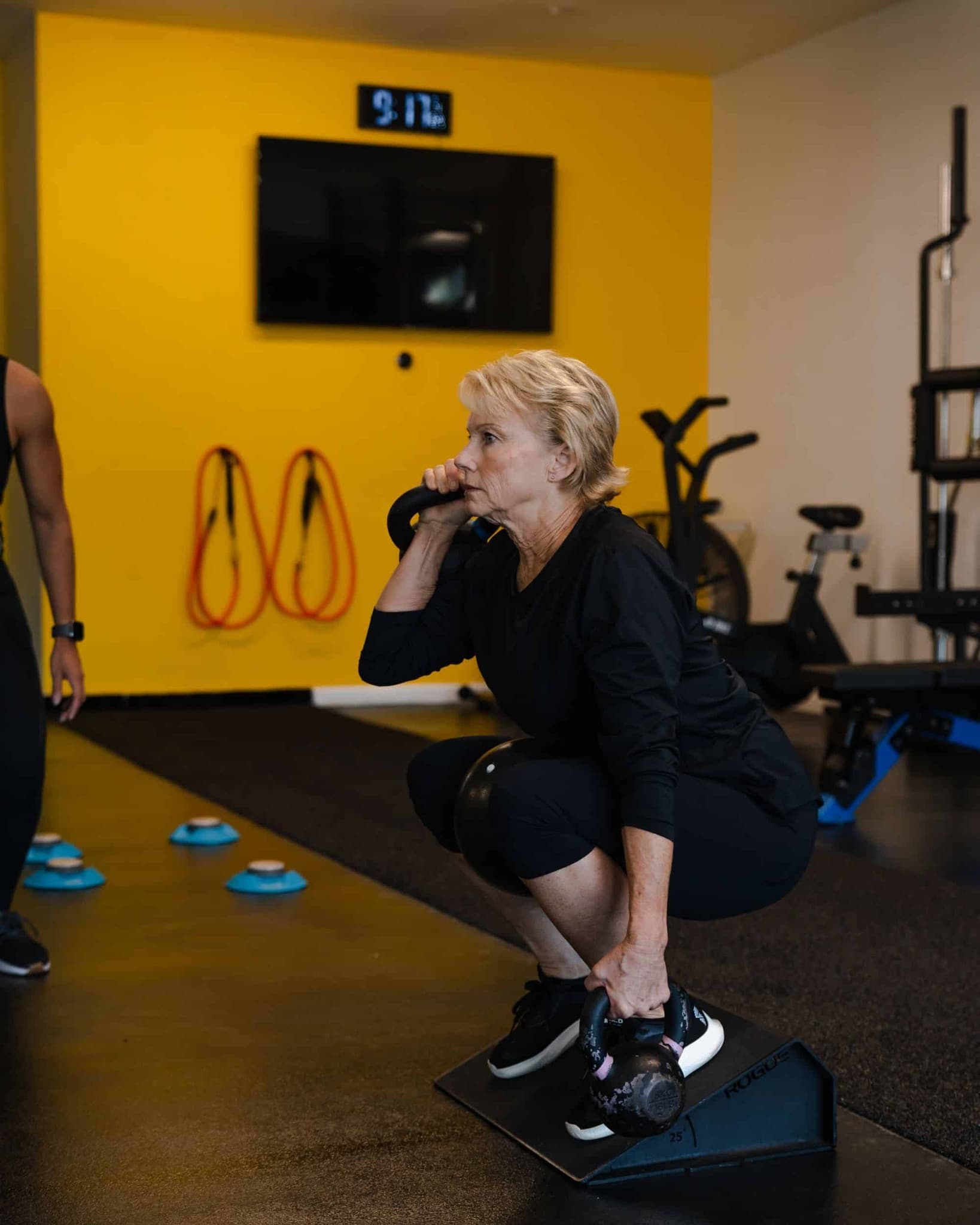 The same client lifting a kettlebell after her assessment