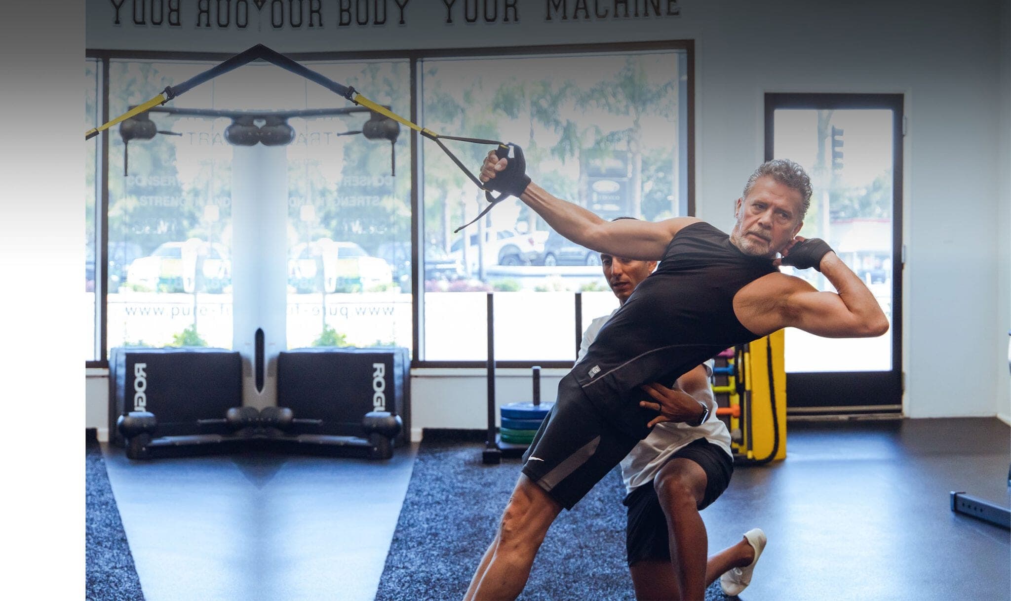 Two clients training side by side on TRX straps